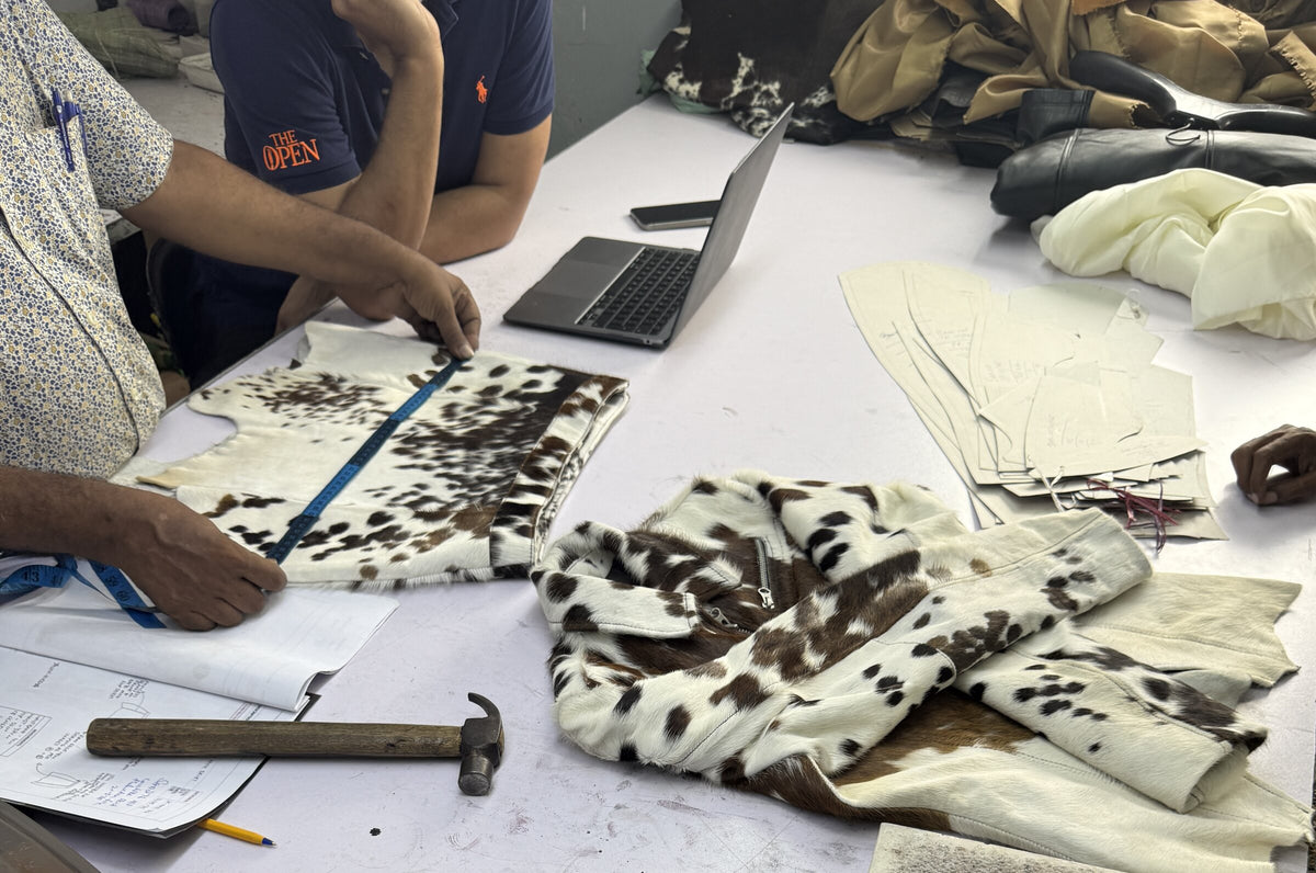 Measuring a hair-on hide against a pattern at the cutting table, Karachi